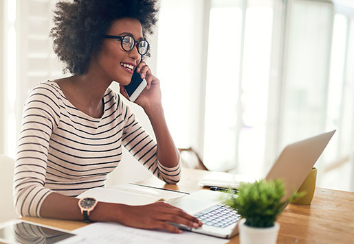 Woman using a laptop and cell phone for a Zoom conference